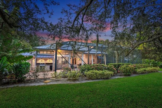 a front view of a house with a garden and tree