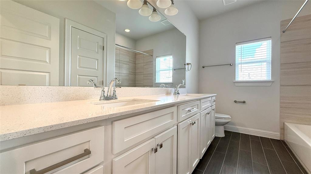 601 C-Bar Ranch Trail, Unit 27 Cedar Park, TX 78613 - Photo 25 of 29 Bathroom featuring a dual vanity with a speckled countertop, white cabinetry, and brushed nickel hardware