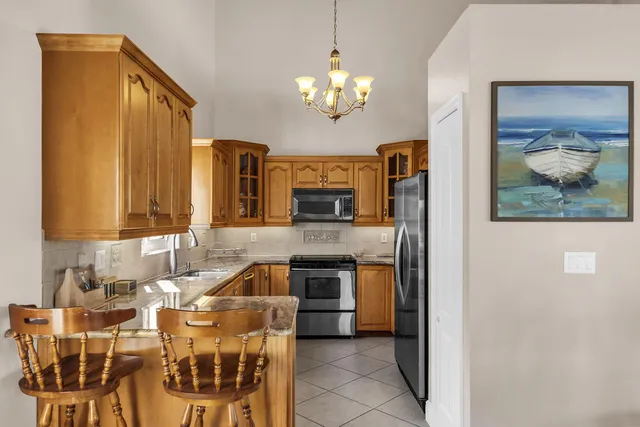 a kitchen with stainless steel appliances granite countertop a refrigerator and a stove top oven