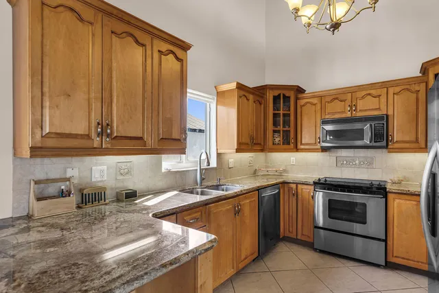 a kitchen with stainless steel appliances granite countertop a sink stove and microwave