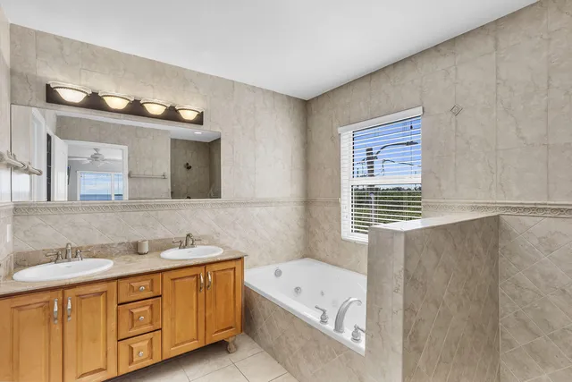 a bathroom with a tub a sink and a window