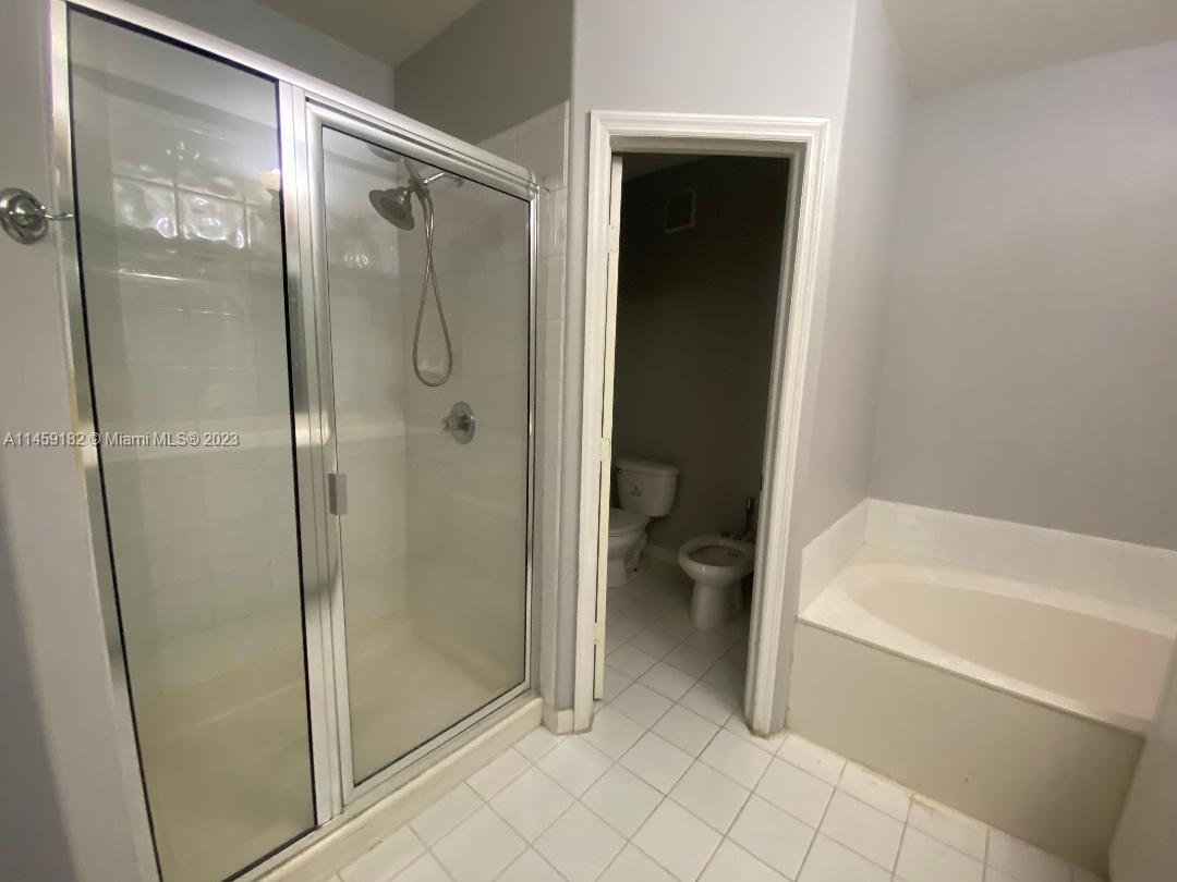 5586 Northwest 112th Path Doral, FL 33178 - Photo 21 of 30 a bathroom with a tub shower and toilet