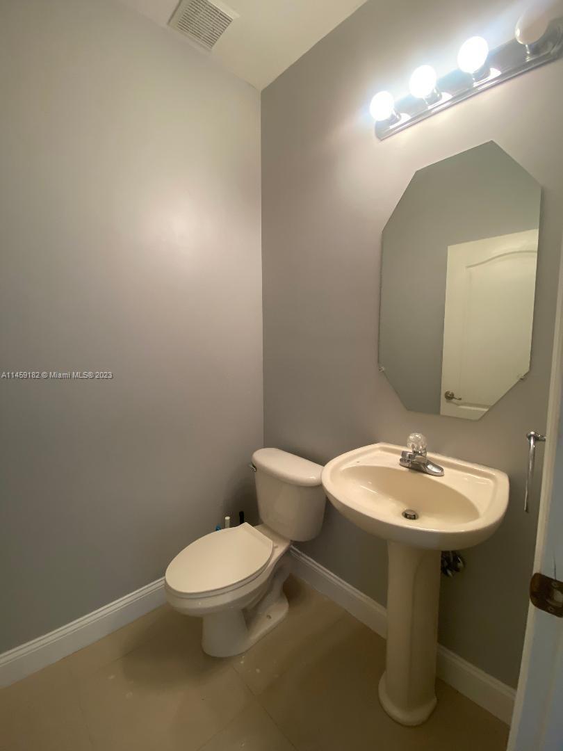 5586 Northwest 112th Path Doral, FL 33178 - Photo 25 of 30 a bathroom with a toilet sink and mirror