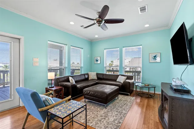 a living room with furniture a ceiling fan and a flat screen tv