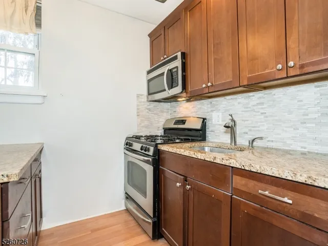 a kitchen with stainless steel appliances granite countertop a sink stove and microwave