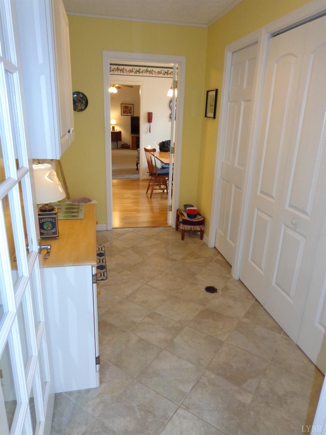 218 Otterview Road Forest, VA 24551 - Photo 29 of 63 Mud room off kitchen (door to carport on left) with laundry closet & wetbar to right + heated ceramic tile flooring , mudroom leads to sunroom