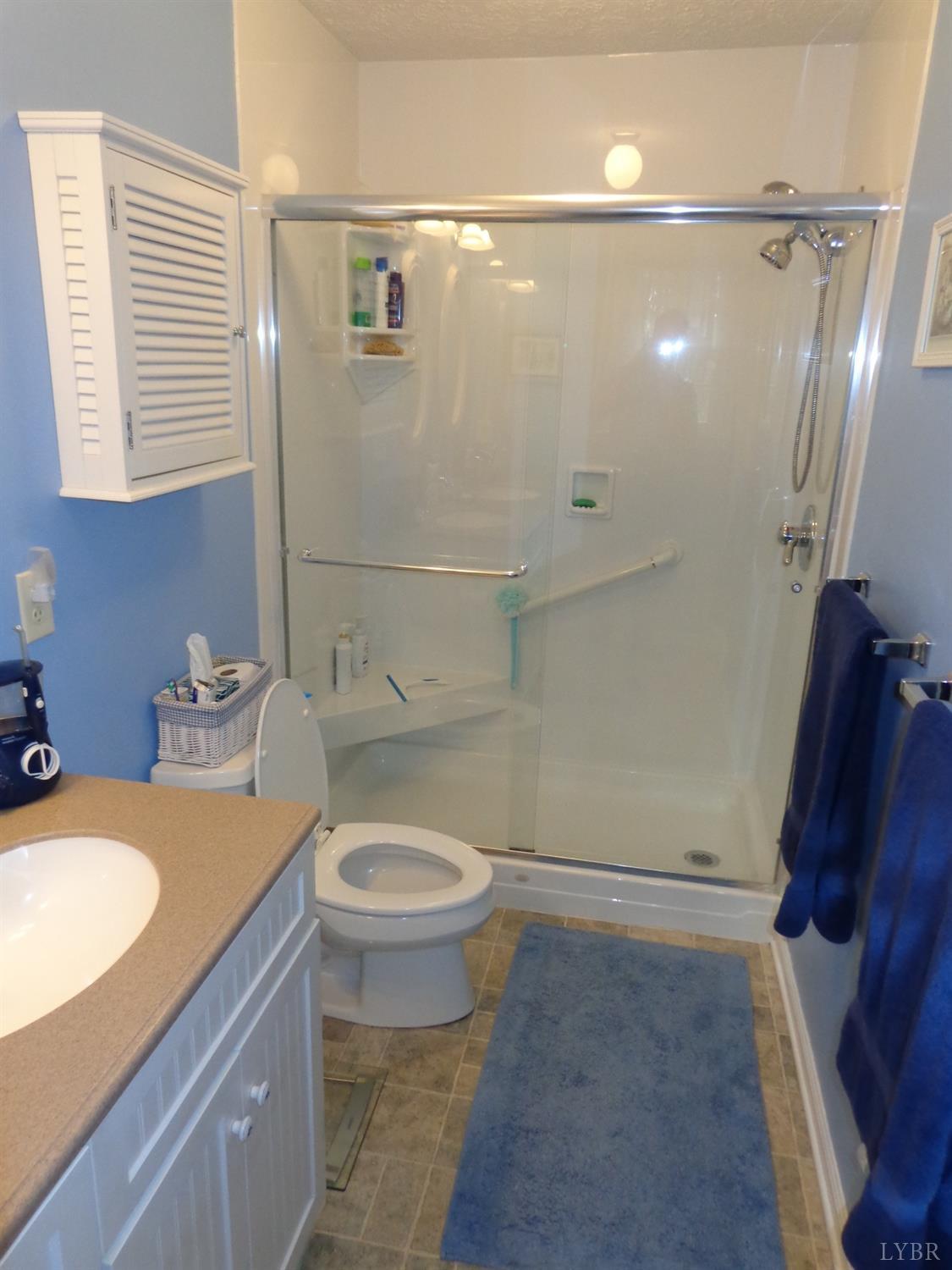 218 Otterview Road Forest, VA 24551 - Photo 52 of 63 Full updated master bath with Corian countertops, double sink vanity, glass doored shower w/ floor to ceiling shower surround