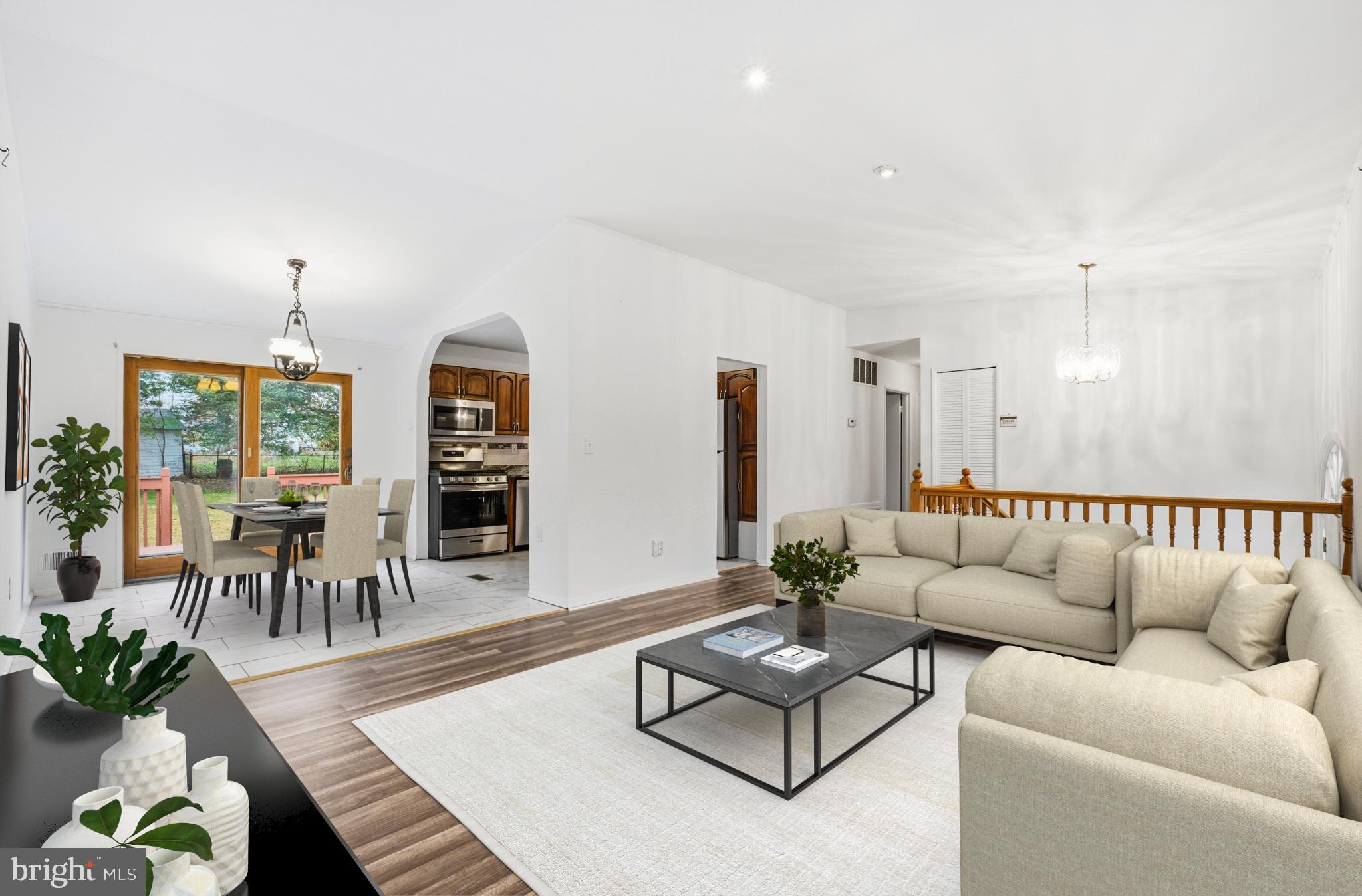 a living room with furniture kitchen view and a large window