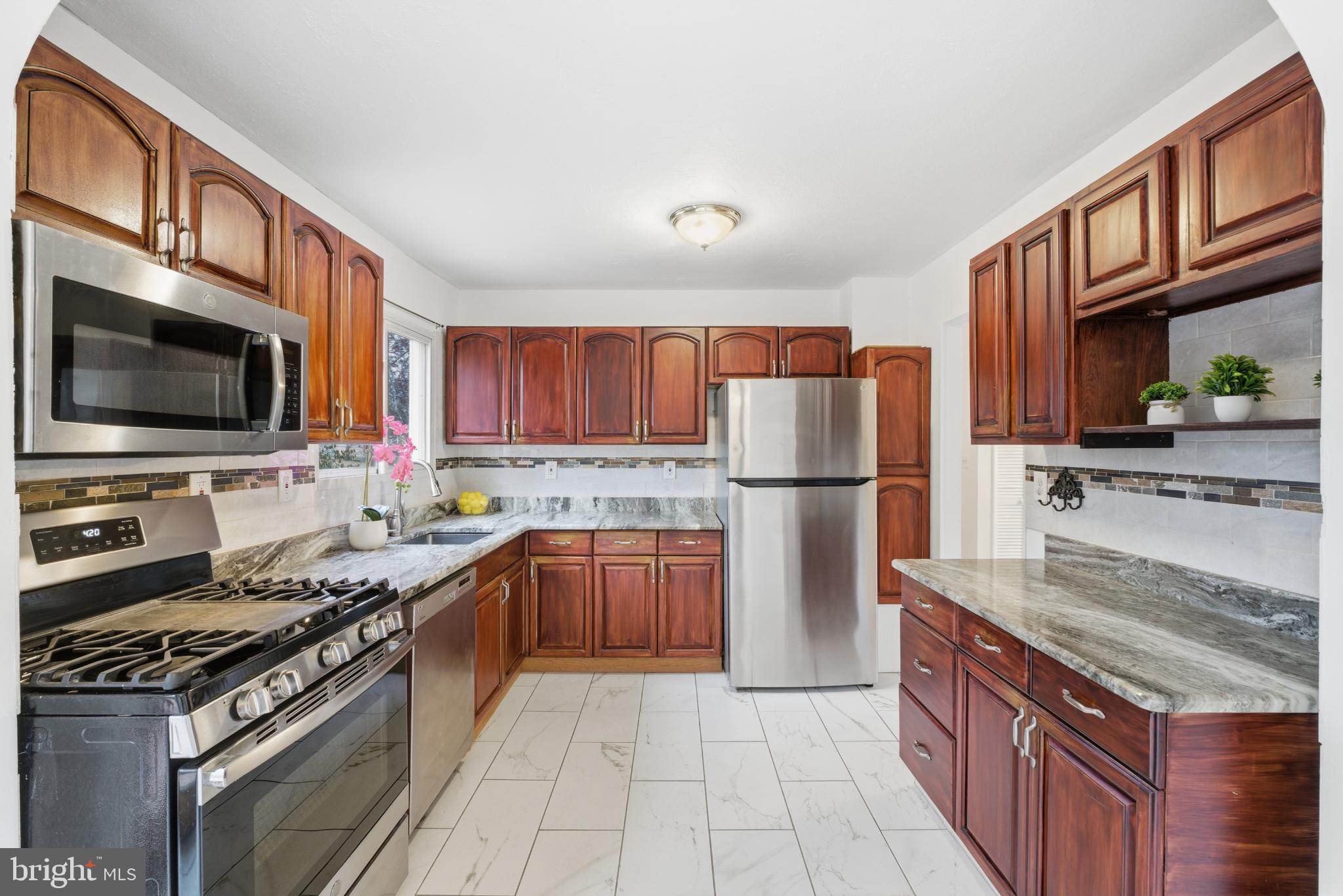 80 Mitchell Avenue Piscataway, NJ 08854 - Photo 14 of 32 a kitchen with stainless steel appliances granite countertop a stove top oven a sink dishwasher a refrigerator and a microwave