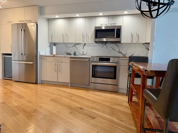 a kitchen with stainless steel appliances granite countertop a stove a sink and a microwave