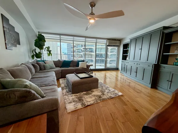 a living room with furniture fireplace and a large window