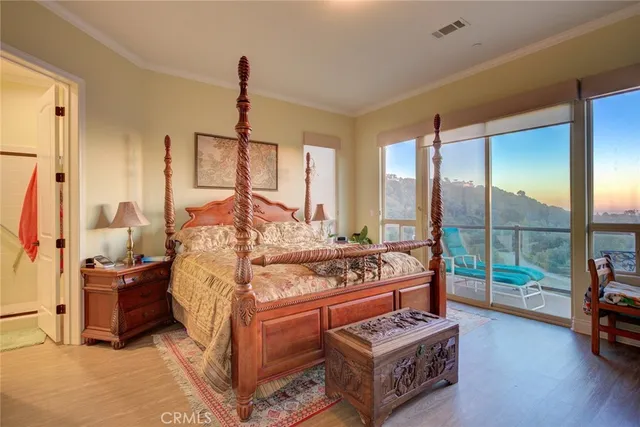 a bedroom with a bed dresser and a large window