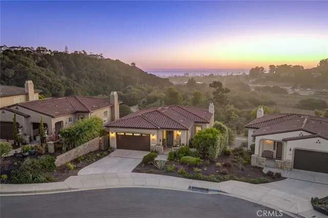 a front view of a house with a yard and mountain