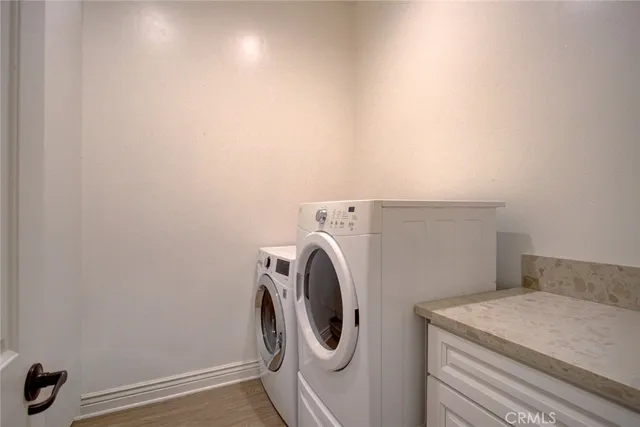 a kitchen with granite countertop a sink stainless steel appliances and white cabinets