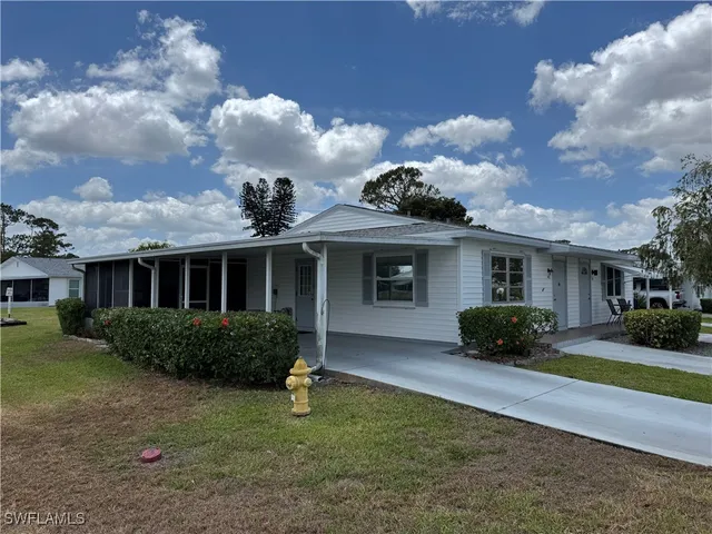 a front view of a house with a garden and plants