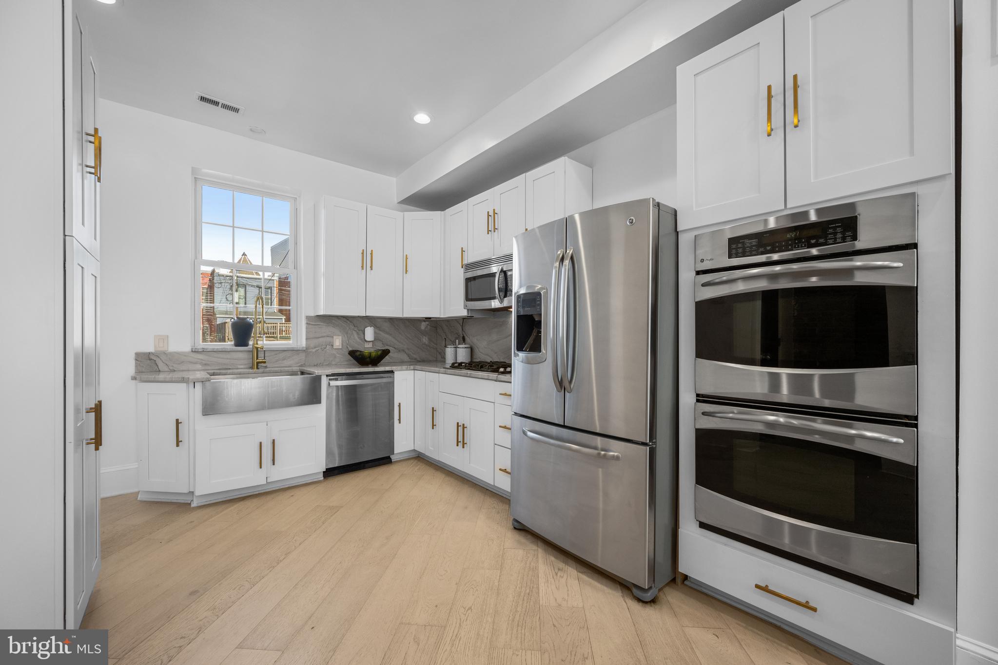 41 R Street Northwest Washington, DC 20001 - Photo 13 of 43 a kitchen with white cabinets and stainless steel appliances