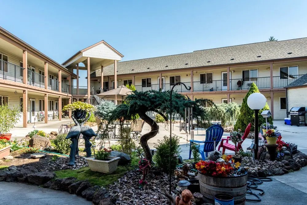 a front view of a house with lots of potted plants
