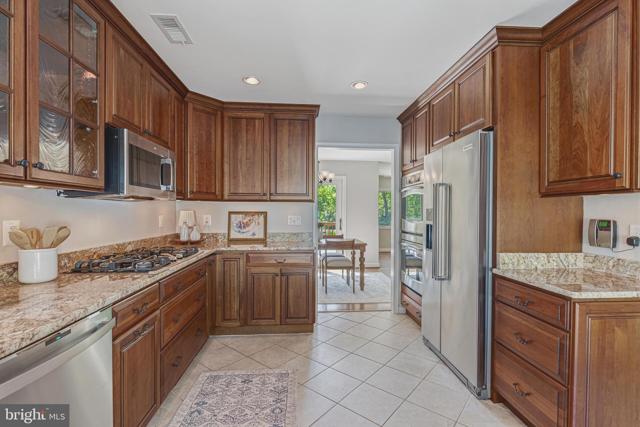 8231 Mc Neil Street Vienna, VA 22180 - Photo 2 of 9 a kitchen with stainless steel appliances granite countertop a stove top oven a refrigerator a sink and dishwasher