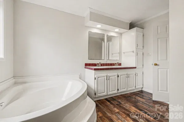 a bathroom with a bathtub a shower a sink and a mirror