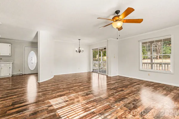 a view of an empty room with window and wooden floor