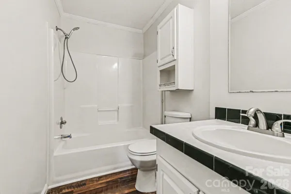 a bathroom with a granite countertop sink a toilet and shower