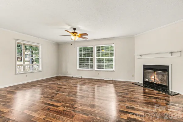 a view of an empty room with a window and fireplace