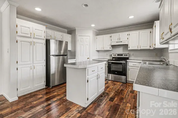 a kitchen with white cabinets and stainless steel appliances