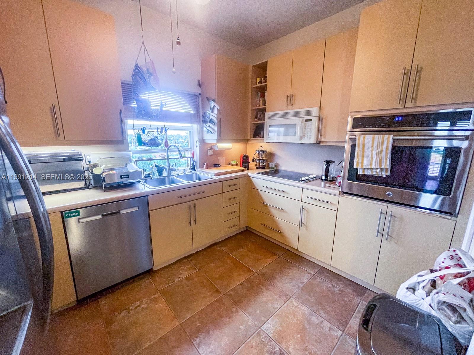 9008 Collins Avenue, Unit 402 Surfside, FL 33154 - Photo 20 of 62 a kitchen with a sink cabinets and window