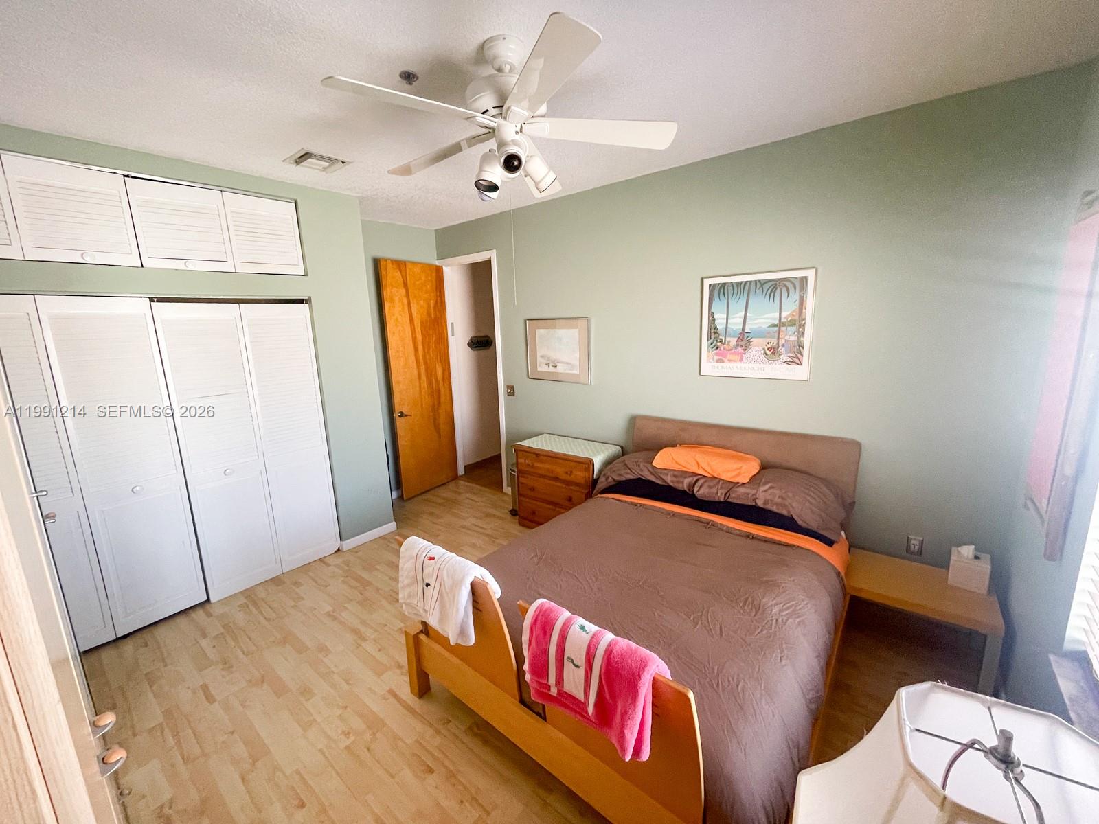 9008 Collins Avenue, Unit 402 Surfside, FL 33154 - Photo 32 of 62 a bedroom with a bed and wooden floor