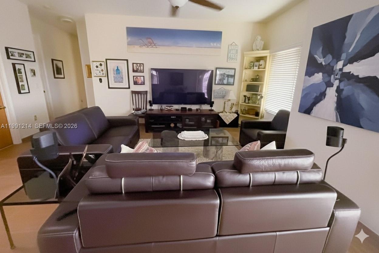 9008 Collins Avenue, Unit 402 Surfside, FL 33154 - Photo 10 of 62 a living room with furniture and a flat screen tv