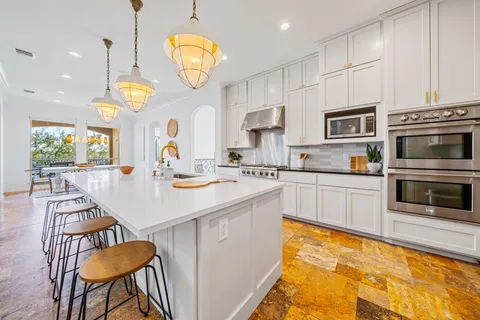 a kitchen with stainless steel appliances a stove a sink and a refrigerator