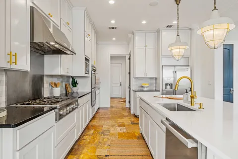 a kitchen with stainless steel appliances granite countertop a sink a stove and cabinets