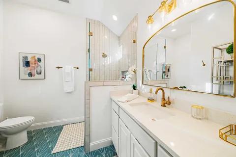 a bathroom with a sink a toilet and a mirror