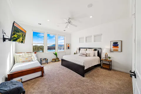 a spacious bedroom with a bed couch and window