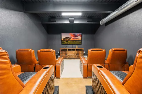a projector room with furniture and a flat screen tv