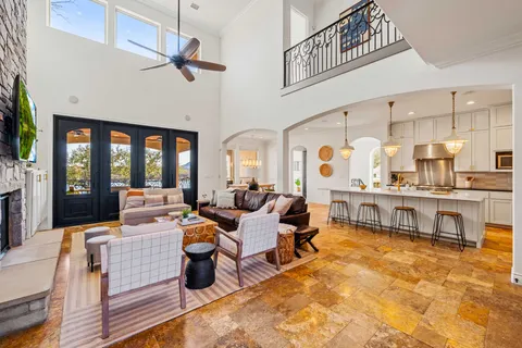 a living room with fireplace furniture and a view of kitchen