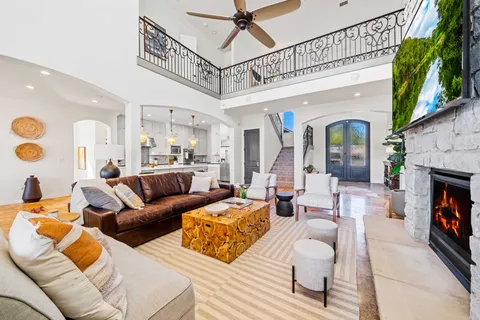a living room with furniture a fireplace and a large window