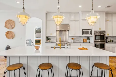 a kitchen with cabinets and chairs
