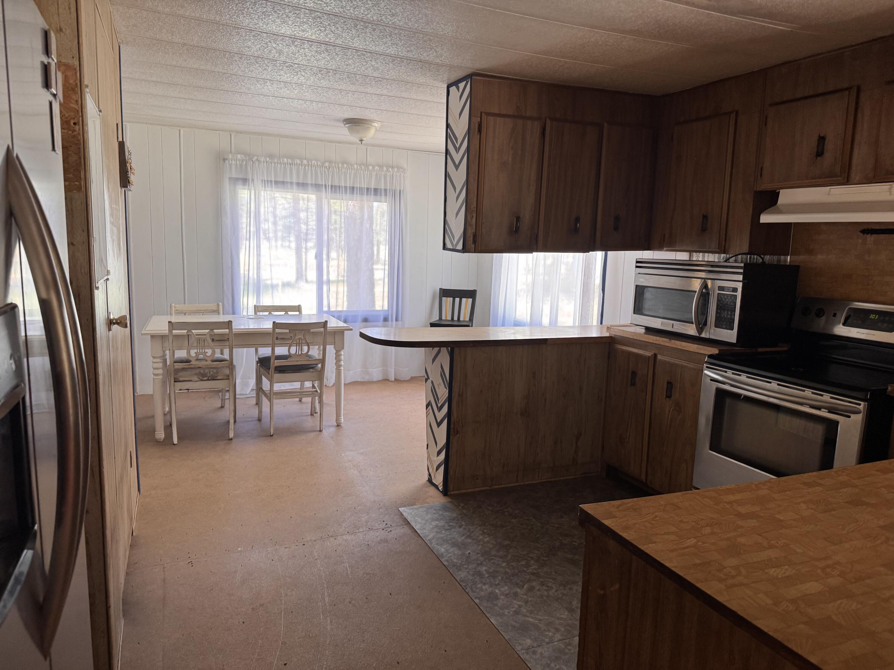 34614 Sprague River Road Sprague River, OR 97639 - Photo 10 of 24 a kitchen with granite countertop a refrigerator stove top oven and cabinets