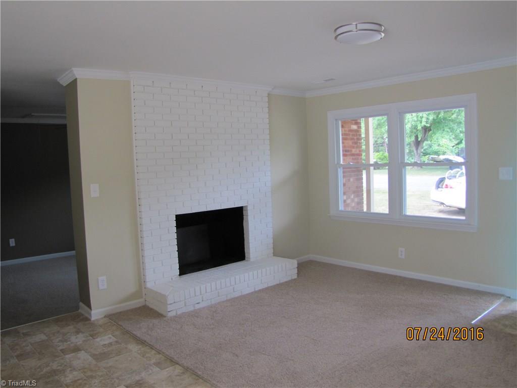 6424 Bowman Road Walnut Cove, NC 27052 - Photo 3 of 12 Living room. All brick white fireplace. New carpet & vinyl floors throughout home. Smooth ceilings and crown molding.