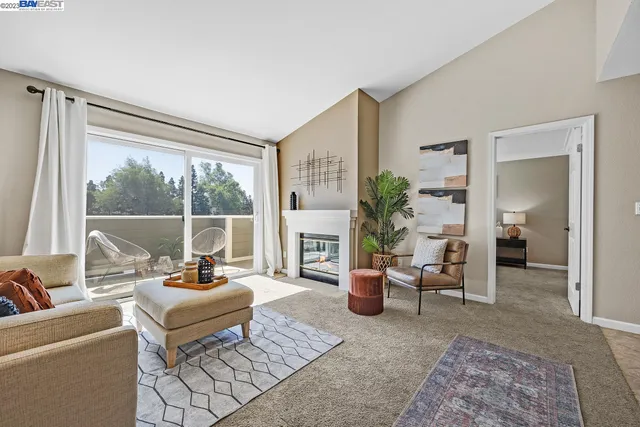 a living room with furniture large window and potted plants