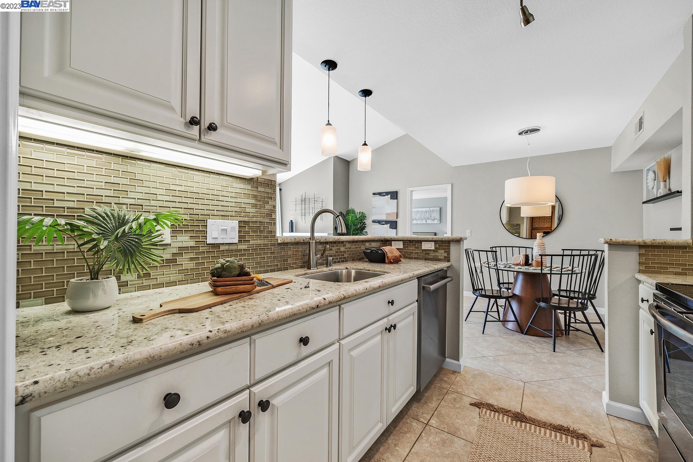 245 Reflections Drive San Ramon, CA 94583 - Photo 13 of 42 a kitchen with kitchen island granite countertop a sink a counter space and cabinets
