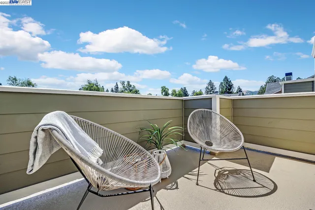 a balcony with wooden floor table and chairs
