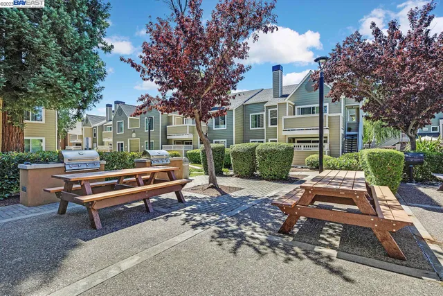 a view of a patio with a table and chairs next to a yard