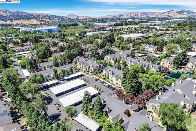 an aerial view of residential houses with outdoor space and trees