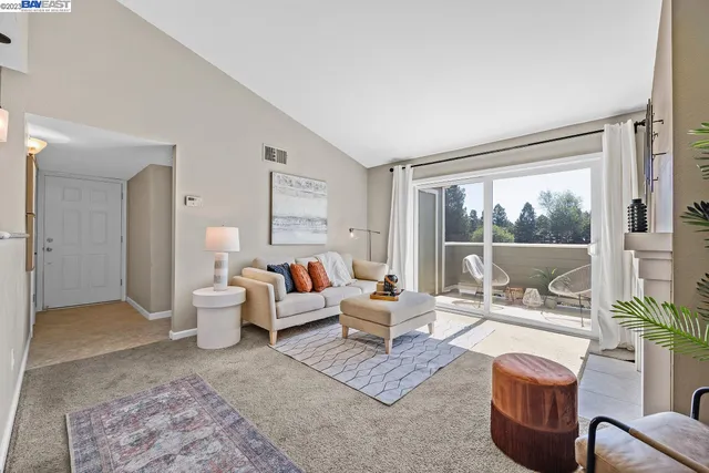 a living room with furniture large window and a table