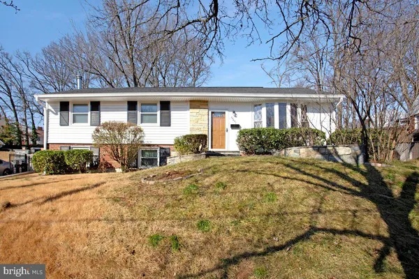 a front view of house with yard and trees around