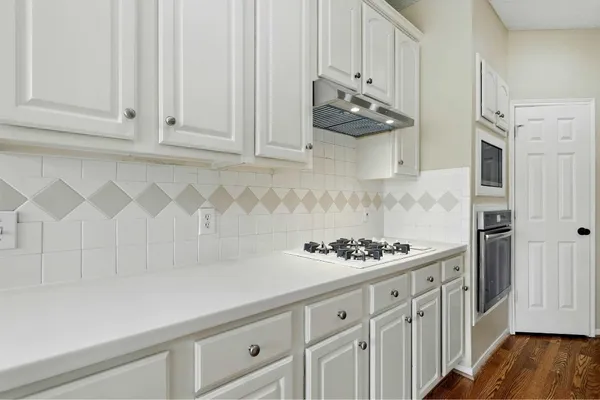 a kitchen with white cabinets and a stove