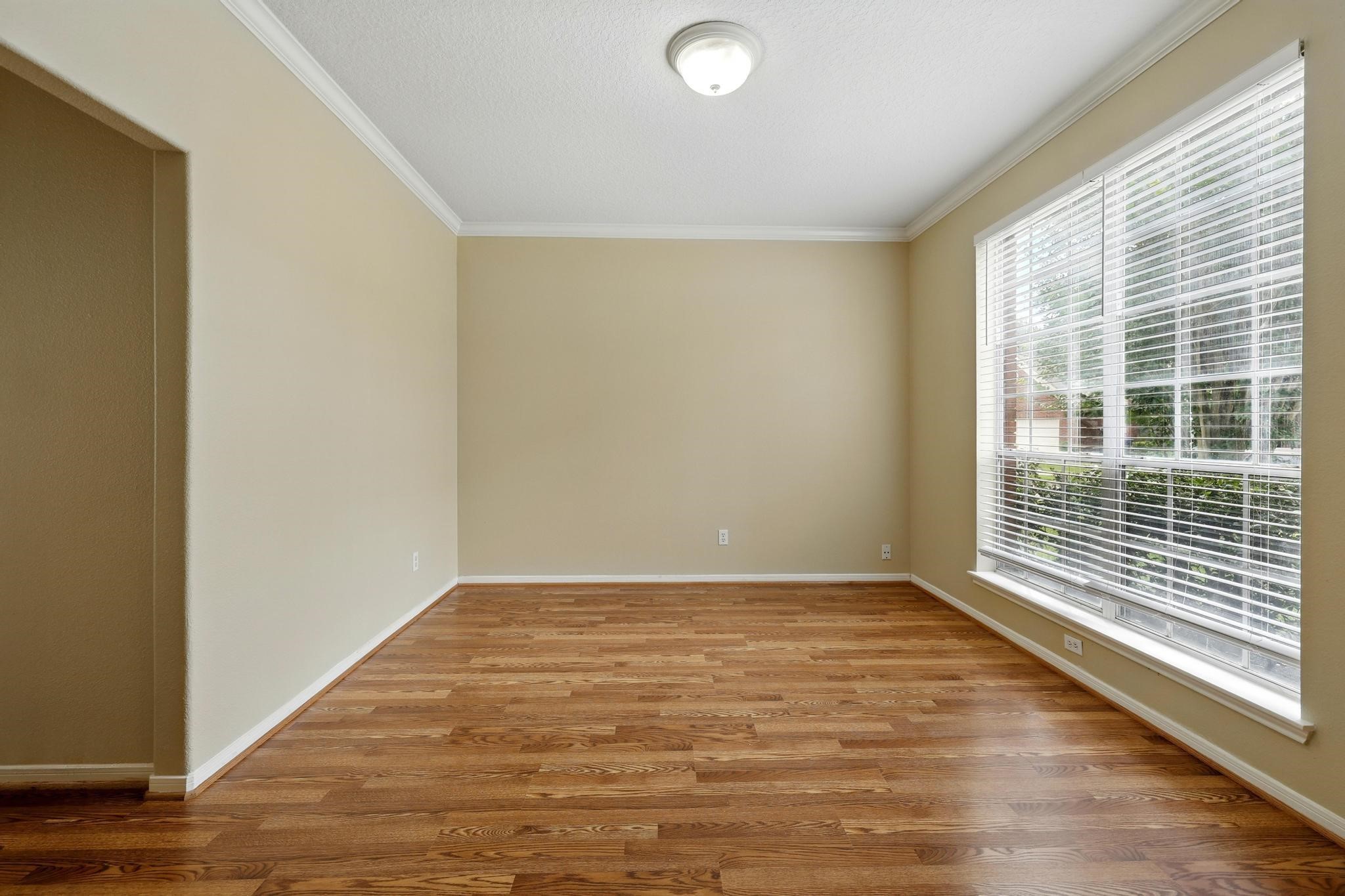 11030 Sprucedale Court Houston, TX 77070 - Photo 4 of 36 a view of an empty room with wooden floor and a window