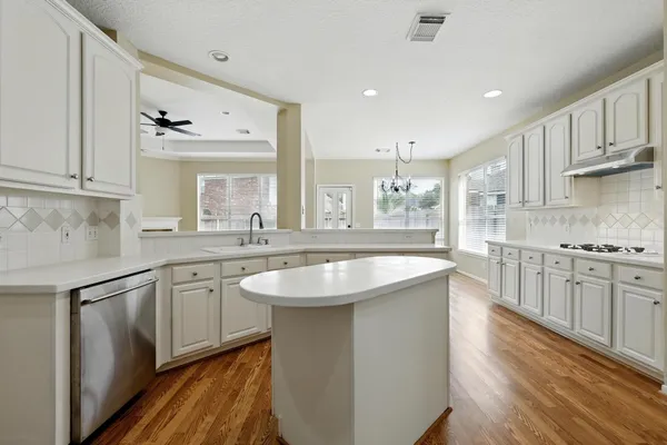 a large kitchen with stainless steel appliances granite countertop a sink and cabinets